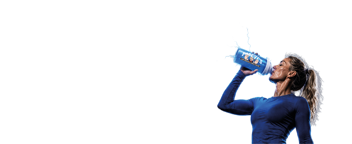 A person with a ponytail wearing a blue long-sleeve shirt, black leggings, and gray sneakers is standing and drinking from a blue water bottle. Description generated by AI